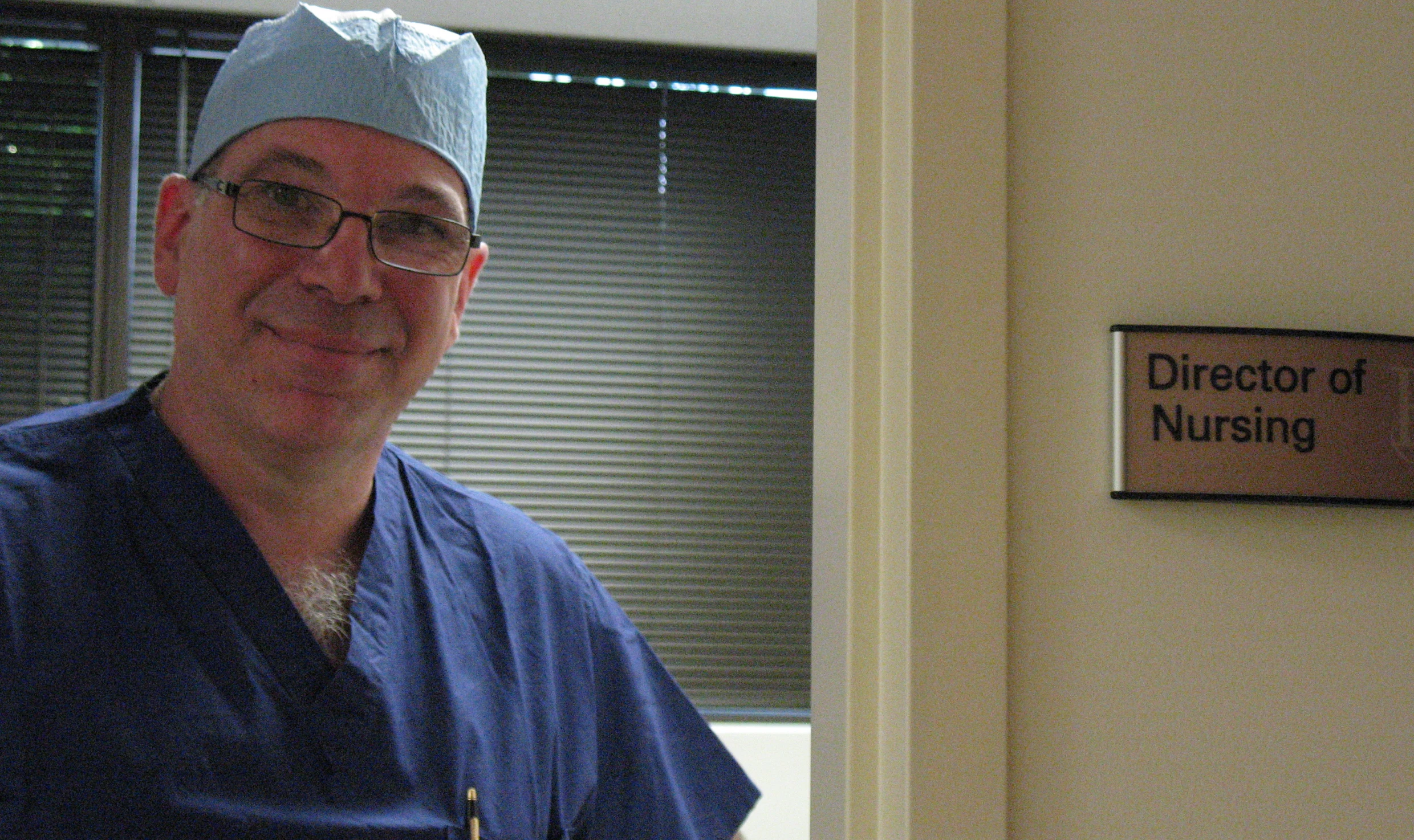 Smiling nurse in blue scrubs